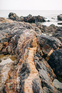 Rock formation on beach against sky