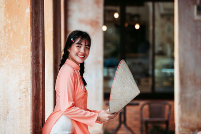 Portrait of a smiling young woman holding umbrella