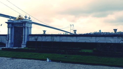 View of bridge over river in city against sky