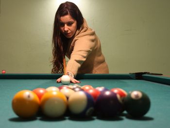 Brunette caucasian girl plays billiards