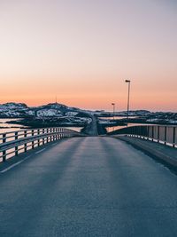 Road by bridge against sky during sunset