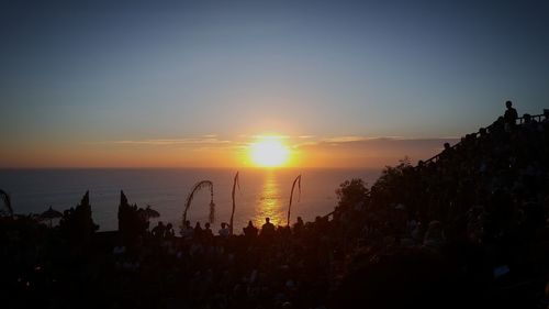 Silhouette trees by sea against sky during sunset