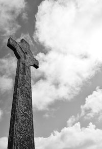 Low angle view of cross at cemetery against sky