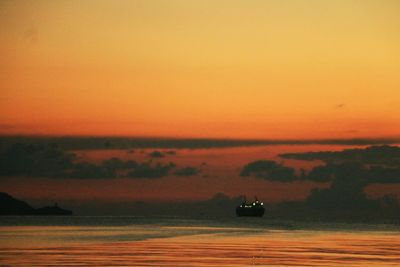 Boat sailing on sea against sky during sunset