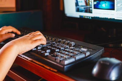 Close-up of person using computer on table at home