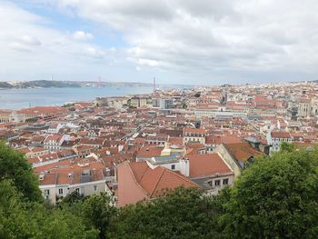 High angle view of townscape by sea against sky