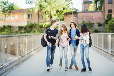 Happy teenagers enjoying while walking on bridge