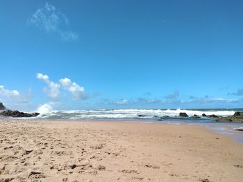 Scenic view of beach against blue sky