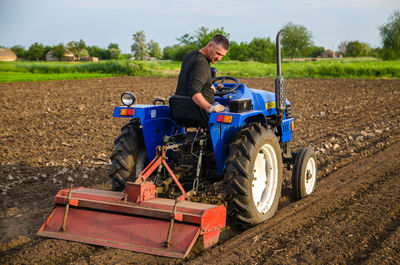 Kherson oblast, ukraine - may 29, 2021. senior farmer works in the field on a tractor