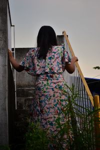 Side view of girl standing against sky