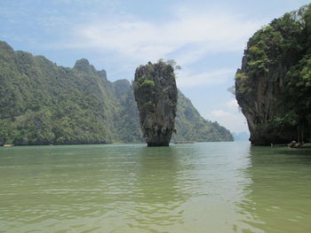 Rock formation by sea against sky