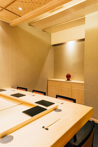 Empty chairs and table in illuminated room