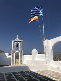 Low angle view of flags on building against clear sky