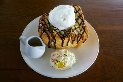 High angle view of dessert served in plate on wooden table