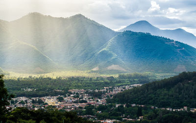 Aerial view of townscape and mountains against sky