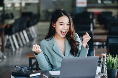 Businesswoman using laptop at cafe