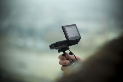 Close-up of human hand against sky