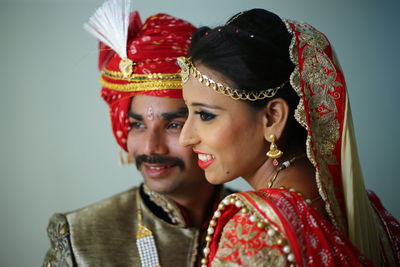 Close-up of smiling bride and groom standing in room