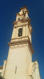 Low angle view of bell tower against blue sky