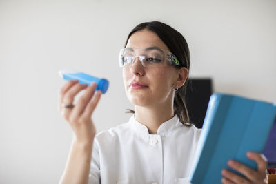 Scientist female with lab glasses, tablet and tubes in a lab