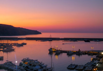 Sailboats in marina at sunset