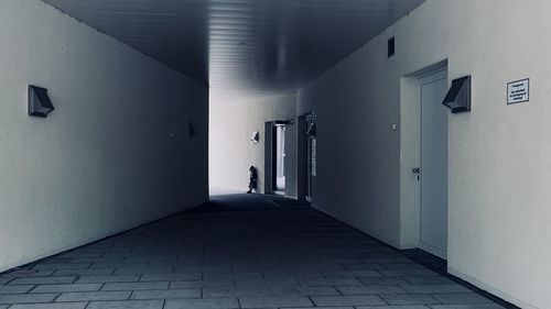 People walking on footpath against building