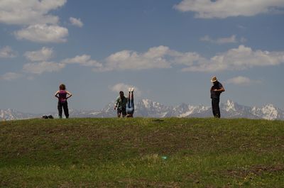 People standing on field against sky