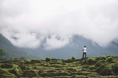 Man standing on mountain against sky