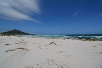 Scenic view of beach against blue sky