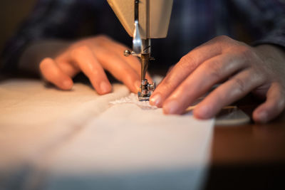 Midsection of person working on sewing machine