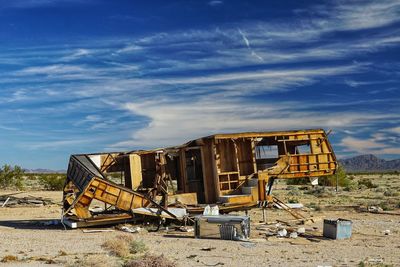 Abandoned rv on field against sky