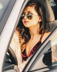 Close-up of young woman looking through car window