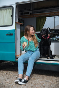 Woman sitting with dog in camper van