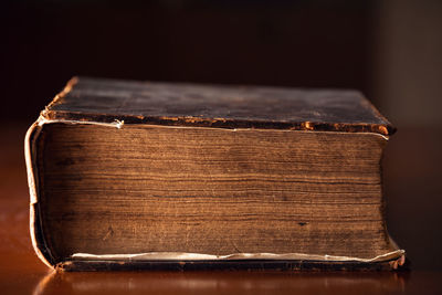 Close-up of open book on table against black background