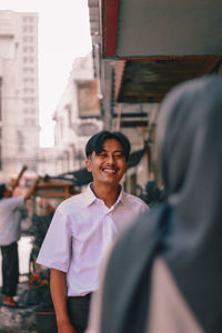 Portrait of smiling man standing on street in city