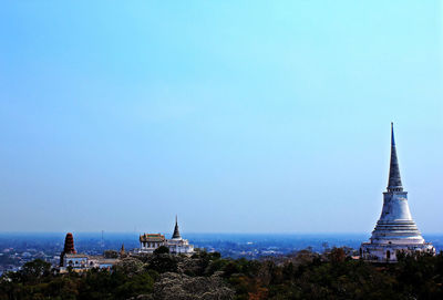 Panoramic view of buildings in city against clear blue sky