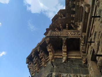 Low angle view of sculptures on building against sky