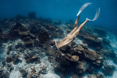 Low section of man swimming in sea