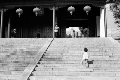 Rear view of woman walking on staircase of building