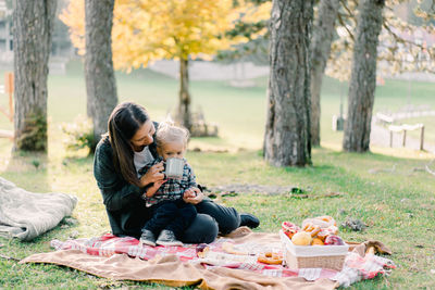 Side view of woman sitting in park