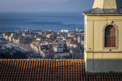 High angle view of cityscape by sea against sky