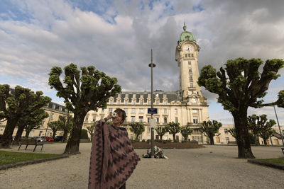 Portrait of happy girl holding flower while standing against limoges station