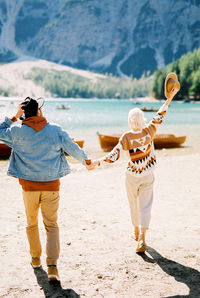 Rear view of couple standing at beach