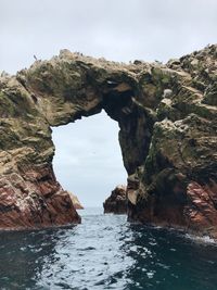 Rock formations by sea against sky