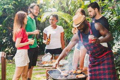 Young man and woman standing on barbecue grill