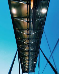 Low angle view of illuminated bridge against blue sky