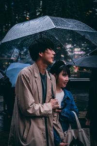 Man and woman standing at rain during rainy season
