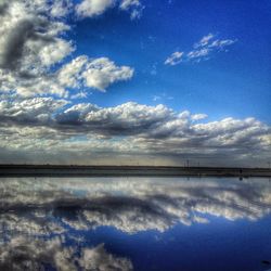 Scenic view of calm lake against cloudy sky