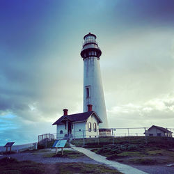 Lighthouse by sea against sky