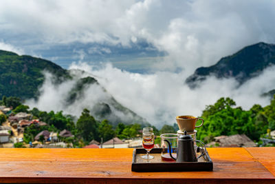 Close-up of drink on table against mountains